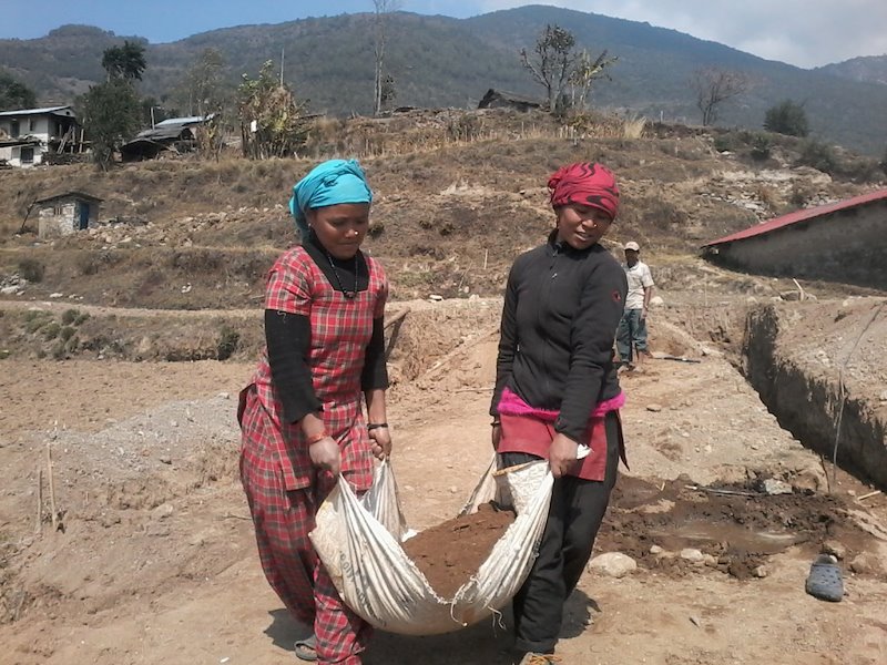 Parents in Lidhugna School work to prepare the ground for school reconstruction.