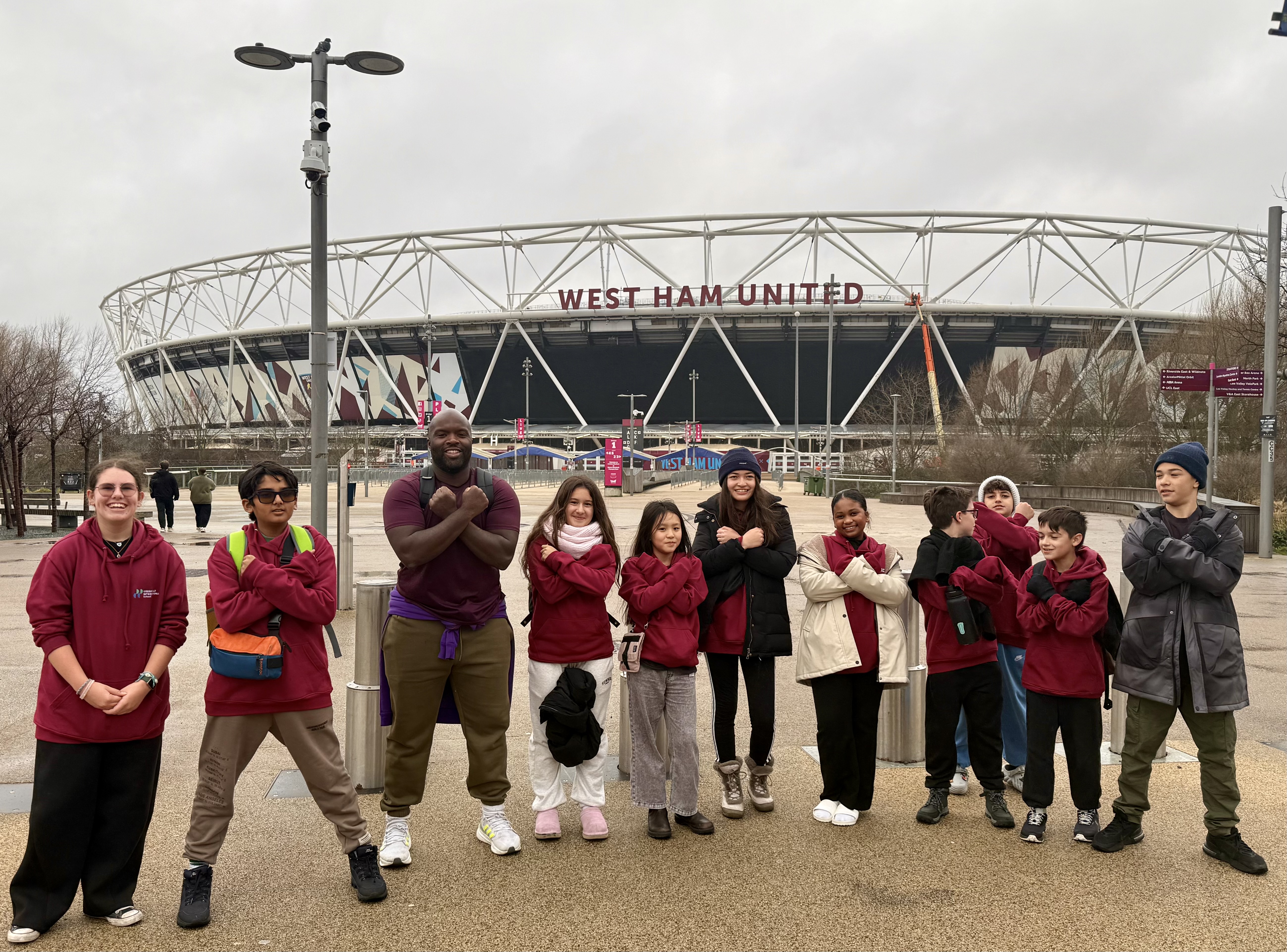 A group of children and an adult stand in front of the West Ham United ...