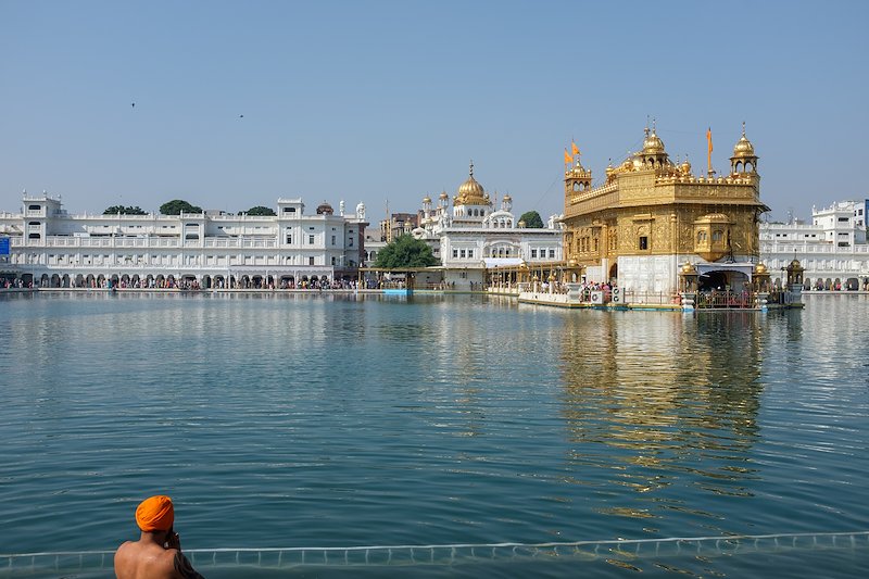 A man bathing in the holy waters at the Golden Temple near the west corner