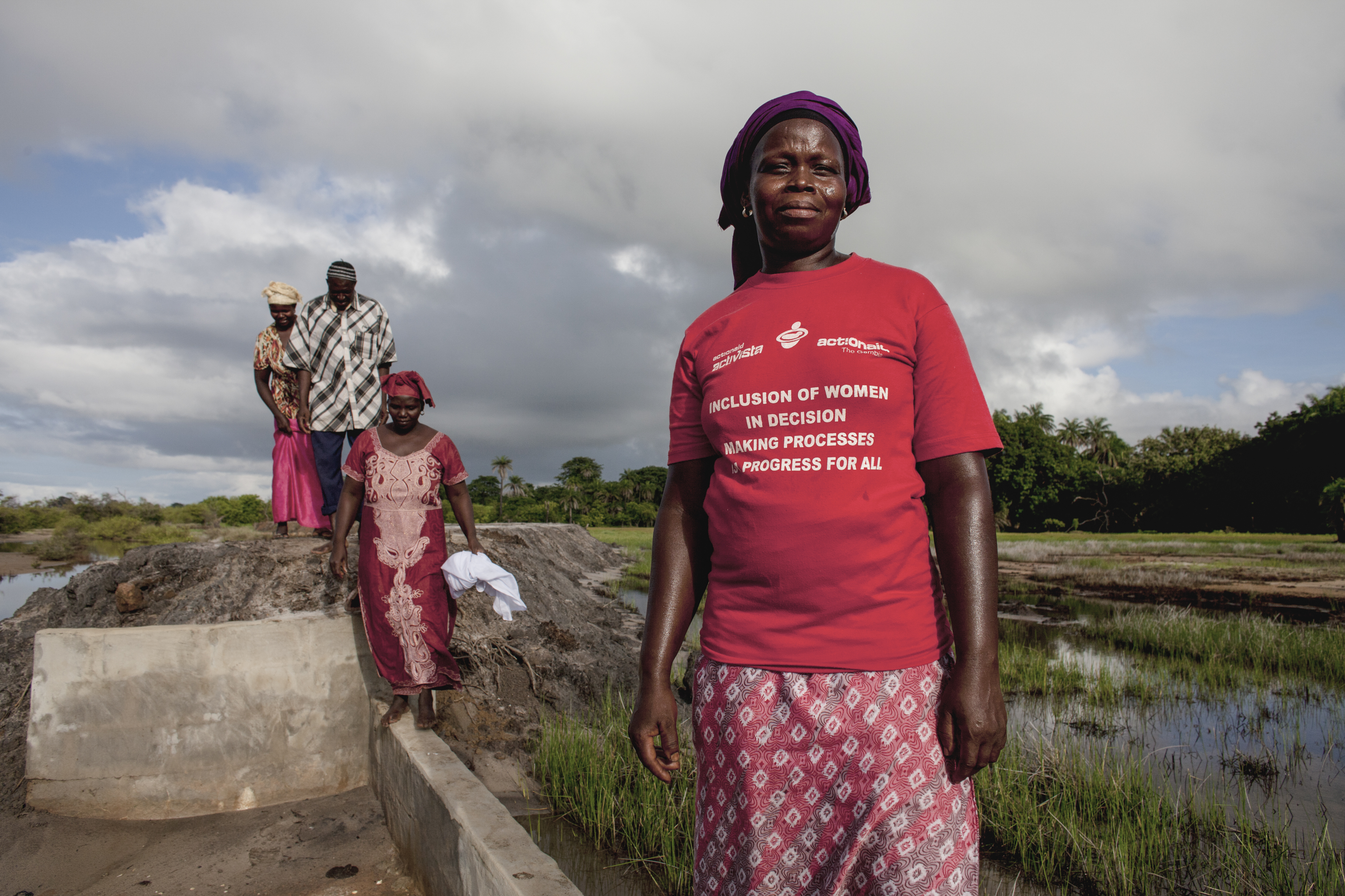 Binta Fadera (foreground) at the dyke which has given her community the land once lost to climate change. © Jane Hahn / ActionAid