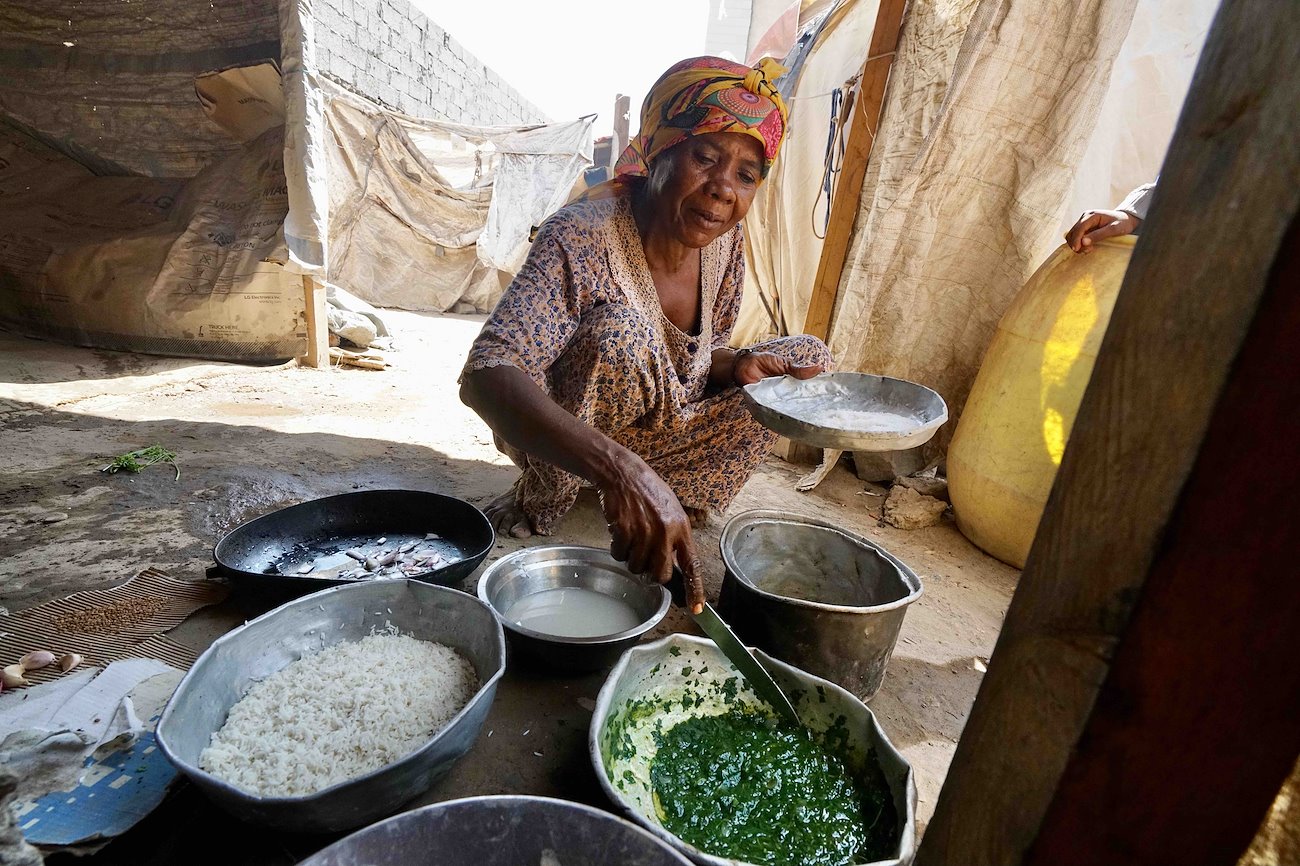A woman prepares food at the Dar Saad informal displacement camp in Aden. ©UNOCHA/Giles Clarke