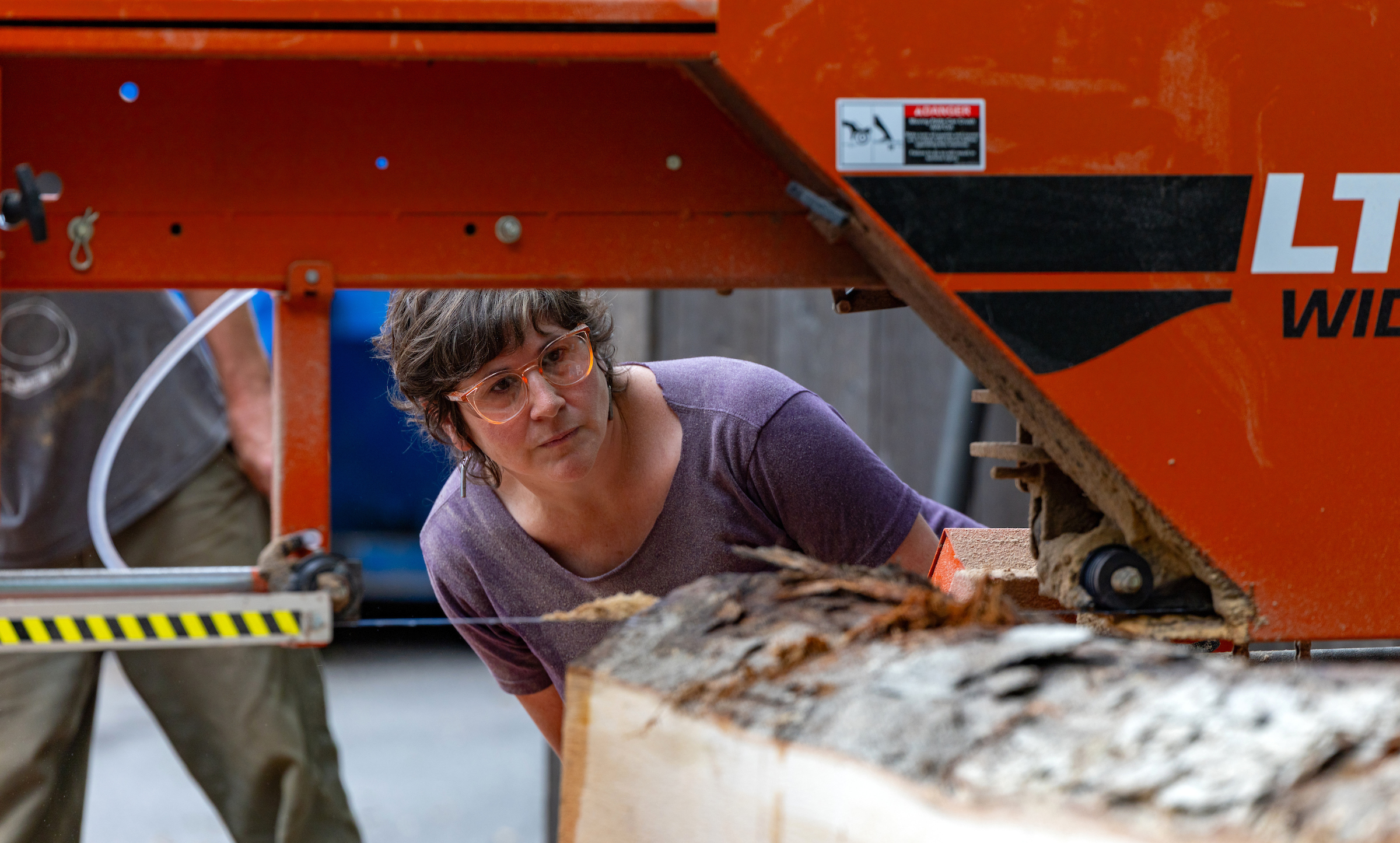 STEAM Studio Staff Leslie Rosenberg demonstrating the mobile sawmill on UNC Asheville's campus.