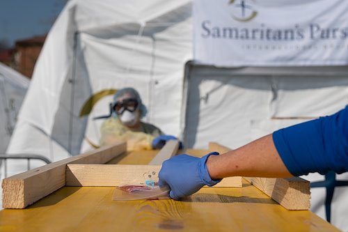 Staff use makeshift wooden bridges to slide items back and forth between the contaminated and clean zones at the EFH in Cremona. Anything - such as blood work - coming from the contaminated zone must be disinfected for safe handling.
