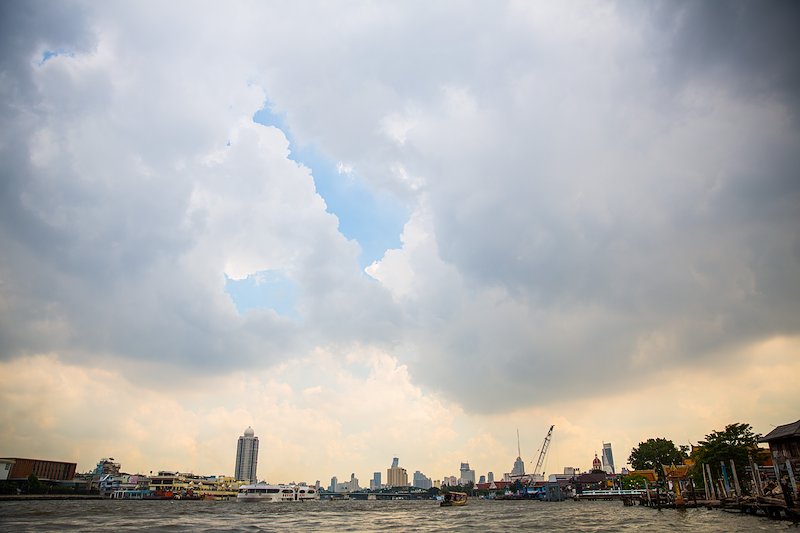 A small batch of blue sky peeks out above Bangkok's Chao Phraya River.