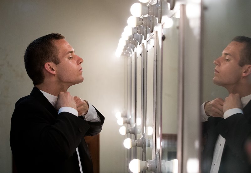 BYU Chamber Orchestra member Brennan Tolman fixes his collar before the concert. Photo by Jaren Wilkey/BYU