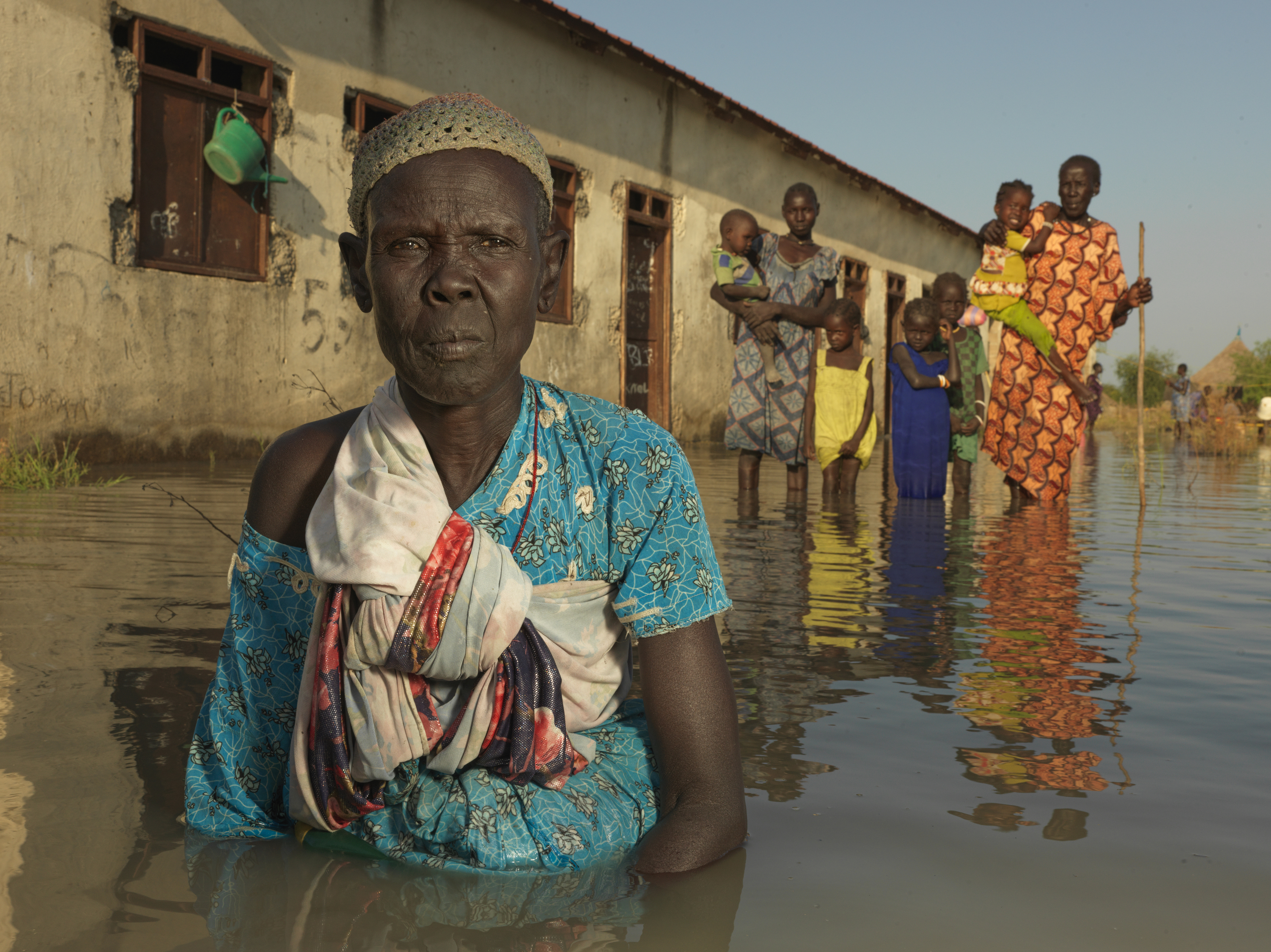 Flood-displaced women and children wait for help in Wangchot primary ...