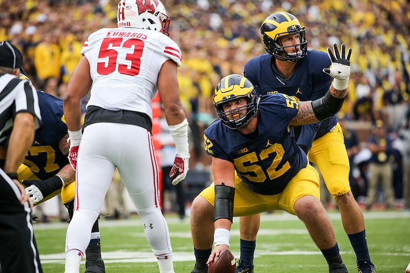 Center Mason Cole and Wilton Speight signal to the offense in the red zone.
