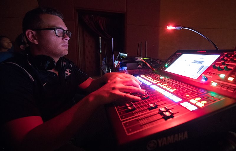 Shaun Ramage works the light board during a concert at the Vietnam Dance Academy. Photo by Jaren Wilkey/BYU