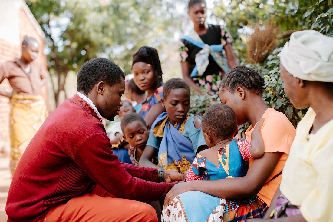 Storyteller Thandy greets a baby and his mom.