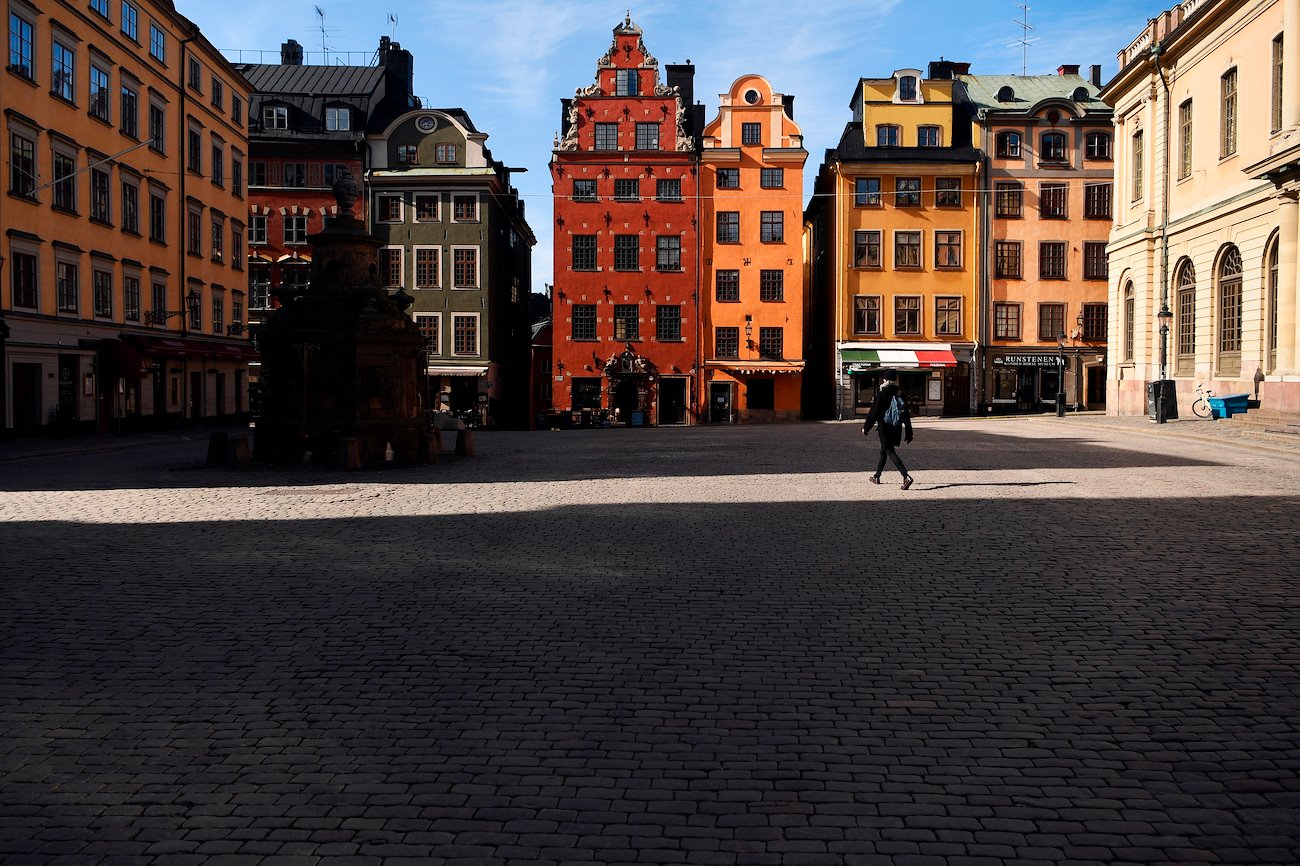 A pedestrian walks through an empty square in the Gamla Stan square in Stockholm, Sweden, on Thursday, March 26, 2020.
