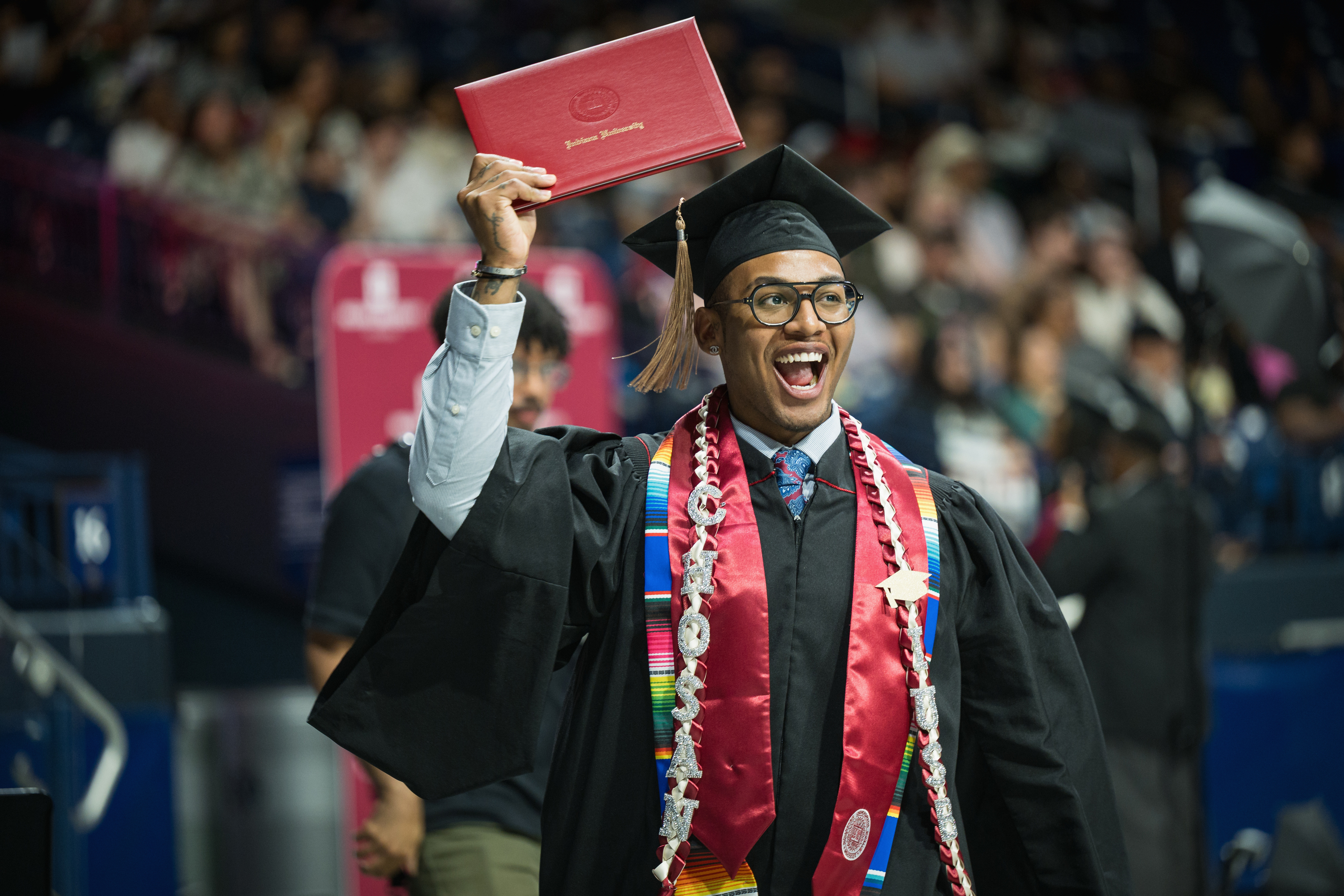 A graduate celebrates with his diploma cover during the IU South Bend ...