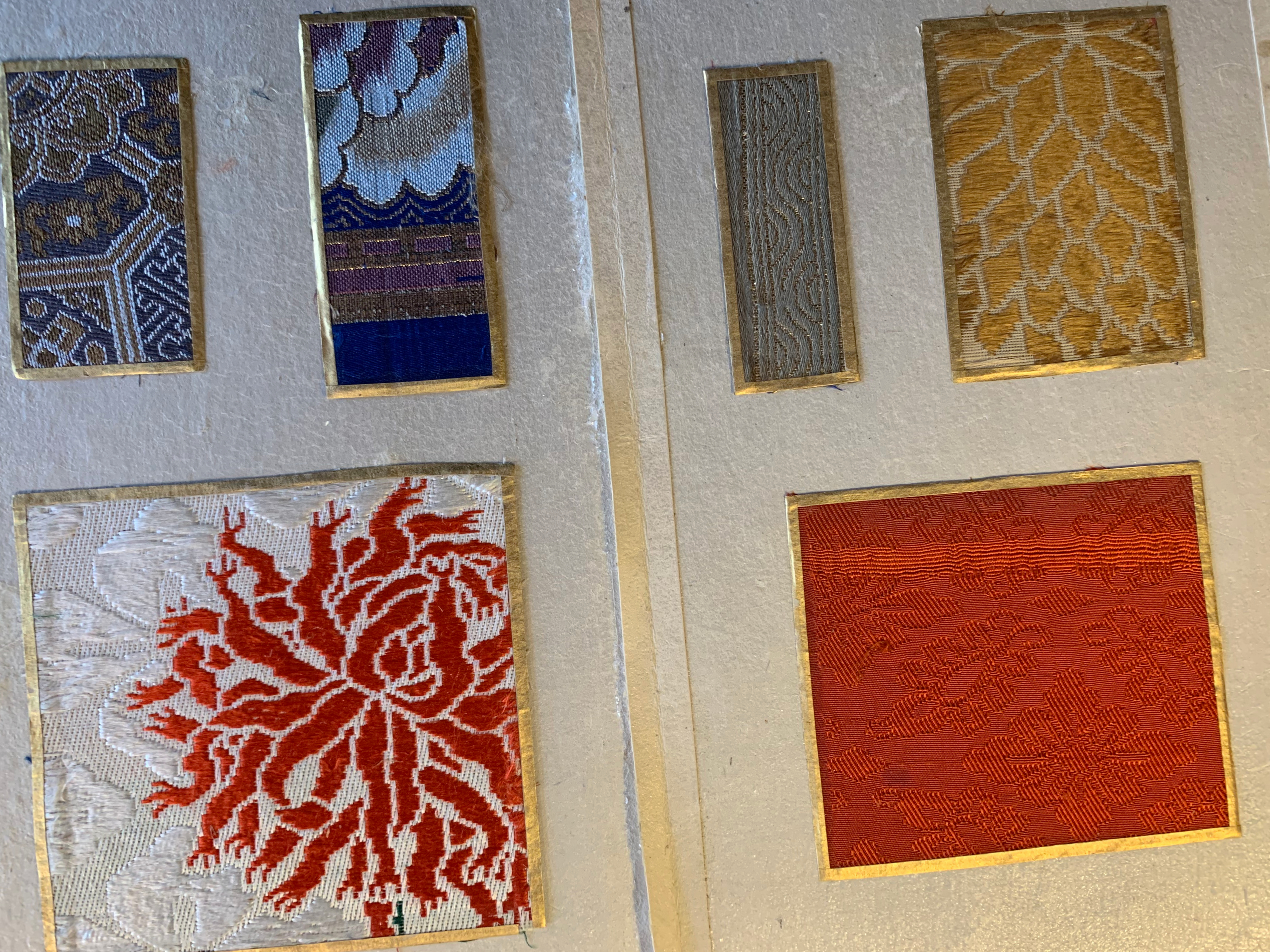 Six Japanese textile samples with gold trim are arranged on a page. The ...