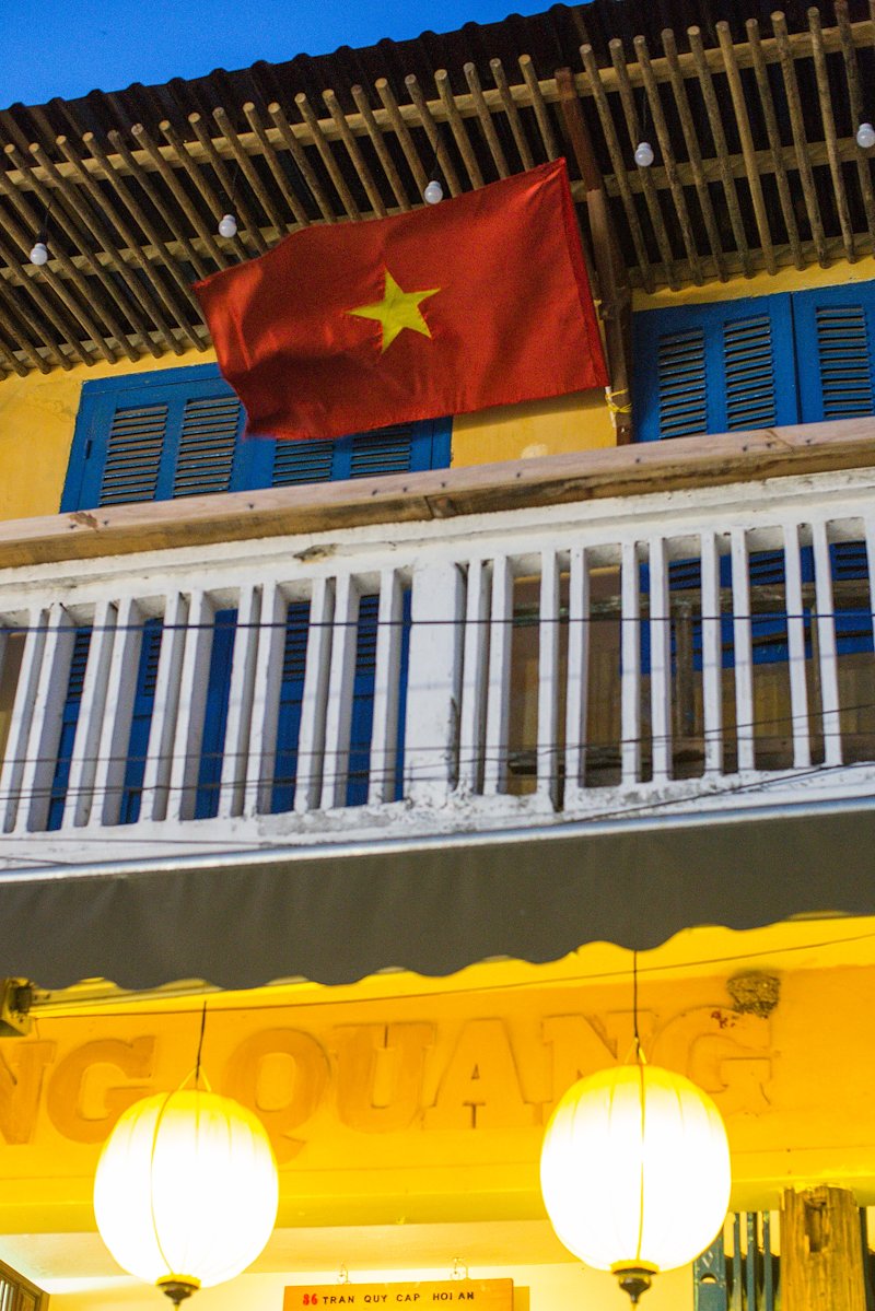 Vietnamese flag waving over the unique Hoi An architecture.