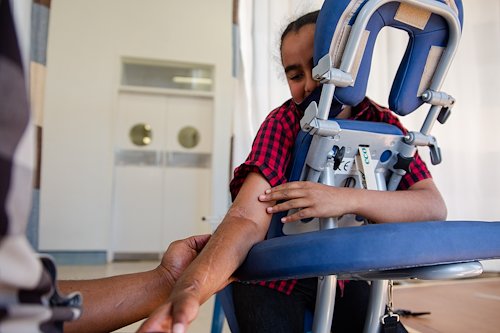 Myla is able to extend her arm fully thanks to her hard work with physiotherapist, Dominic.
