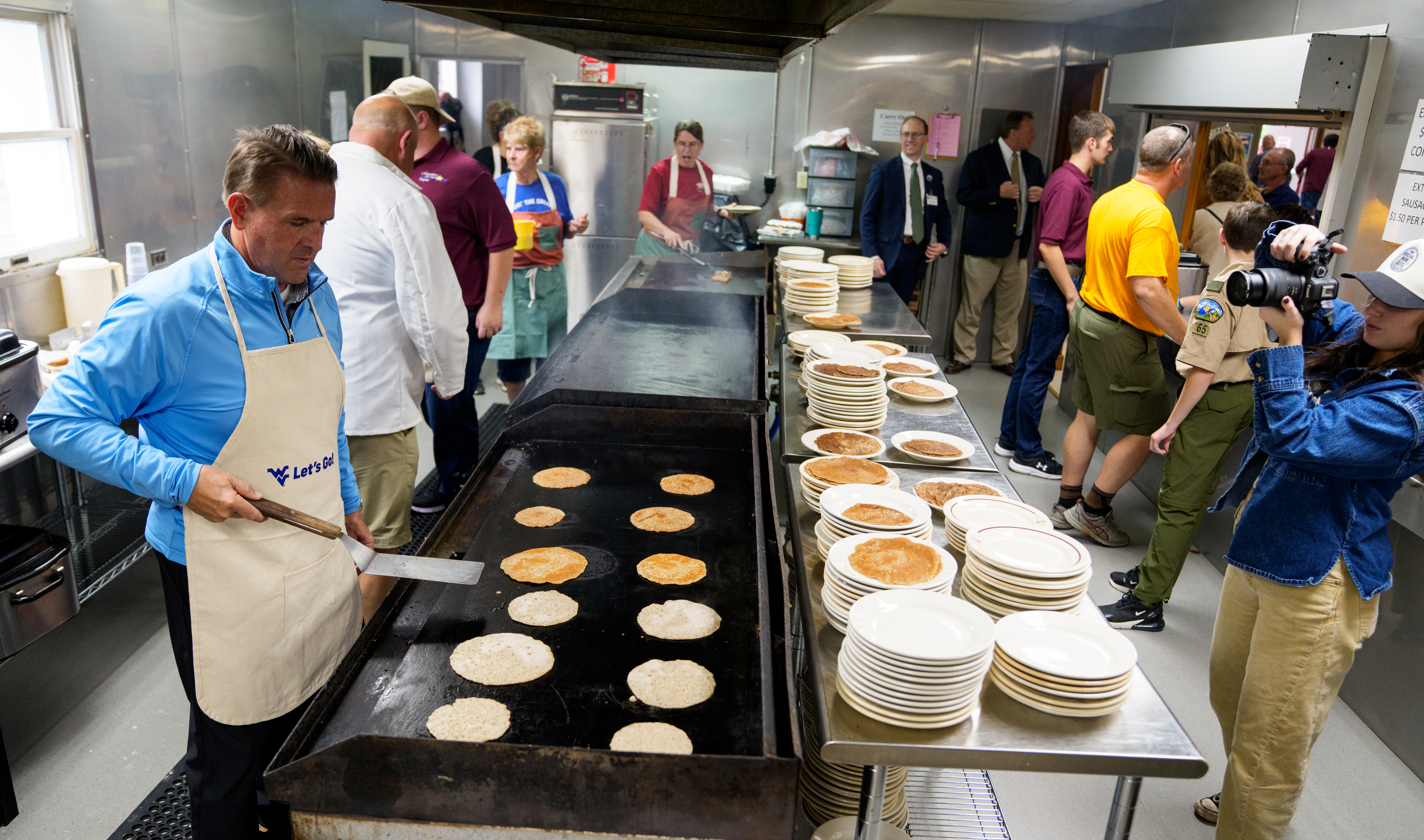 WVU President Michael T. Benson readies to flip a hot buckwheat cakes ...