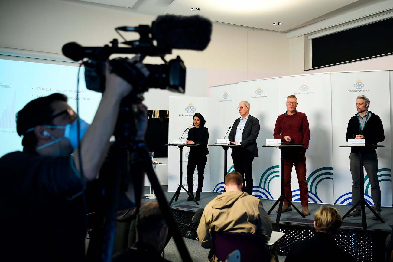 Anders Tegnell, state epidemiologist at The Public Health Agency of Sweden, right, speaks during a news conference as a cameraman, wearing a protective mask, adjusts his camera in Stockholm, Sweden, on Thursday, March 26, 2020.