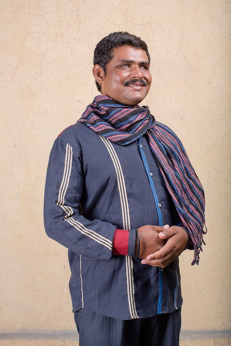 Portrait of Sankarlal standing and smiling.
