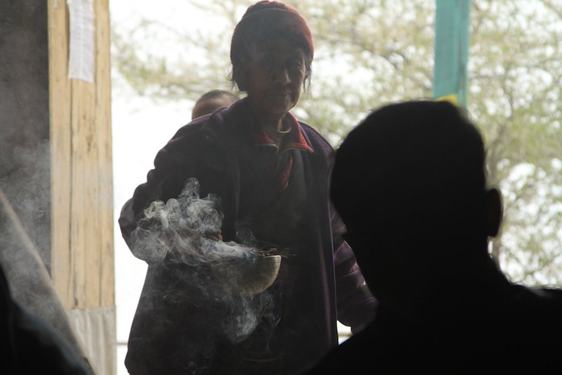 A sherpa lady in Bahane monastery burns holy incense