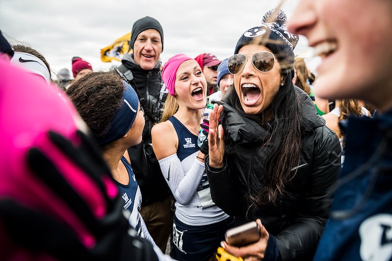 Coach Diljeet Taylor and the women's cross country team celebrate their 10th place finish at Nationals - Photo by Nate Edwards/BYU