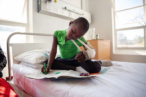 Keith keeps her head in the pages as she settles into the ward before surgery.