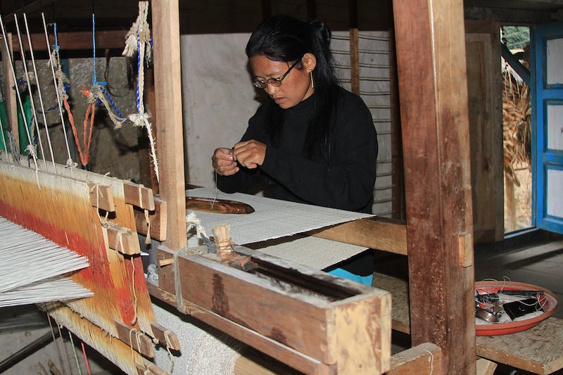 A member of the women's weaving cooperative in Cheskam sets up the loom