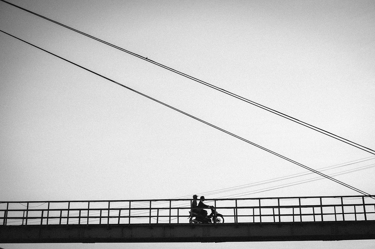 Two men are riding Motorbike across Yellow Bridge, Nusa Penida
