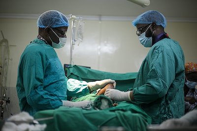 Dr. Sough and Dr. Muka praying for a patient before surgery.