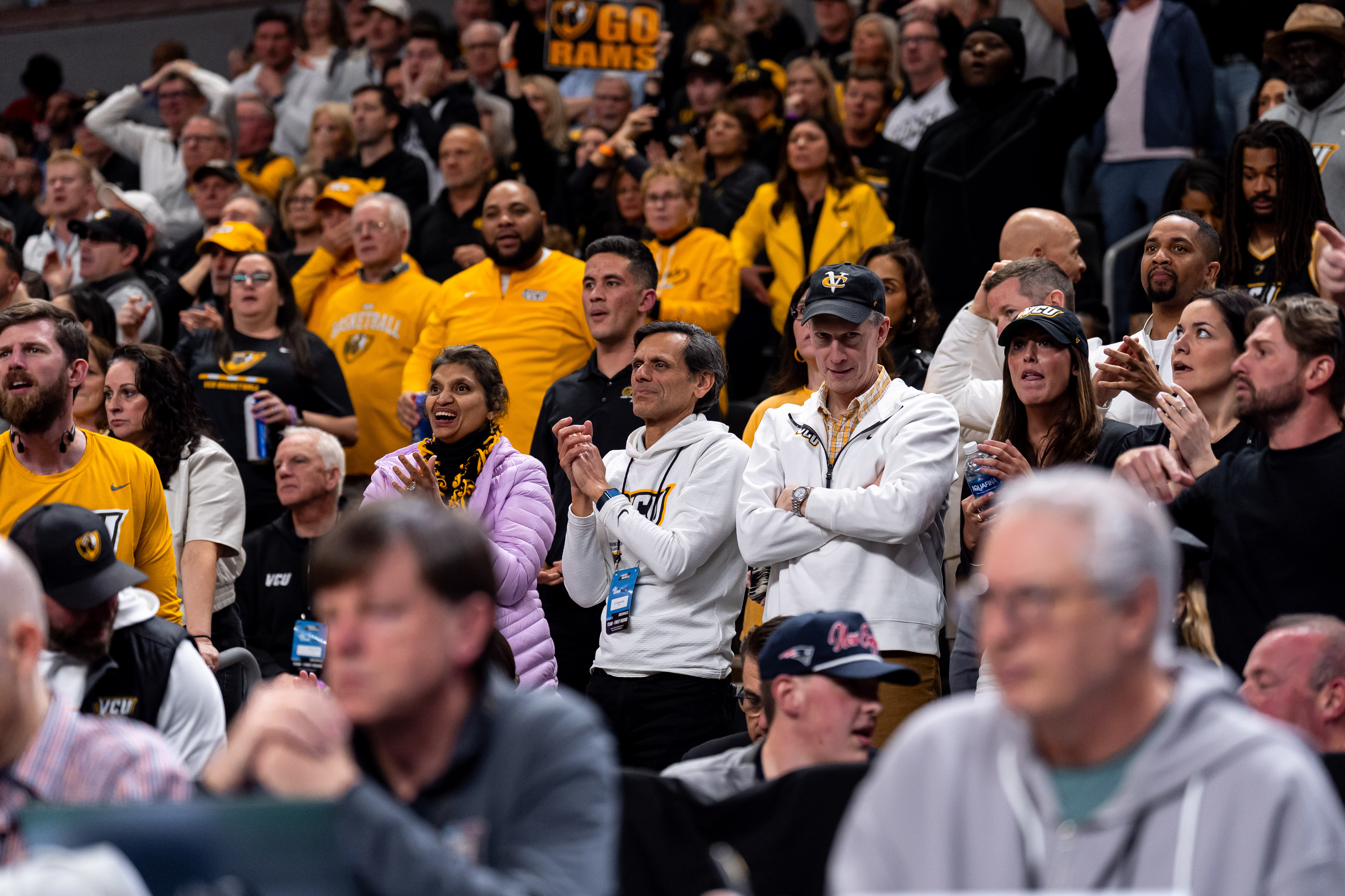 A crowd of VCU Rams fans watches a basketball game. Fans wear black and ...