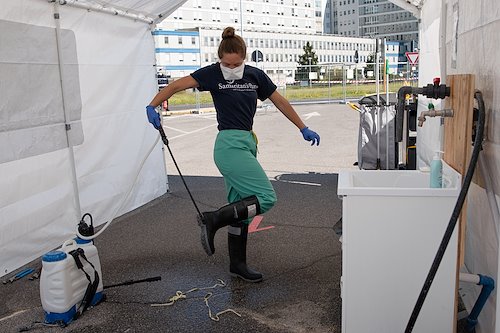 Erin, a nurse, decontaminates her boots  with a chlorine solution on her way out of the hot zone.