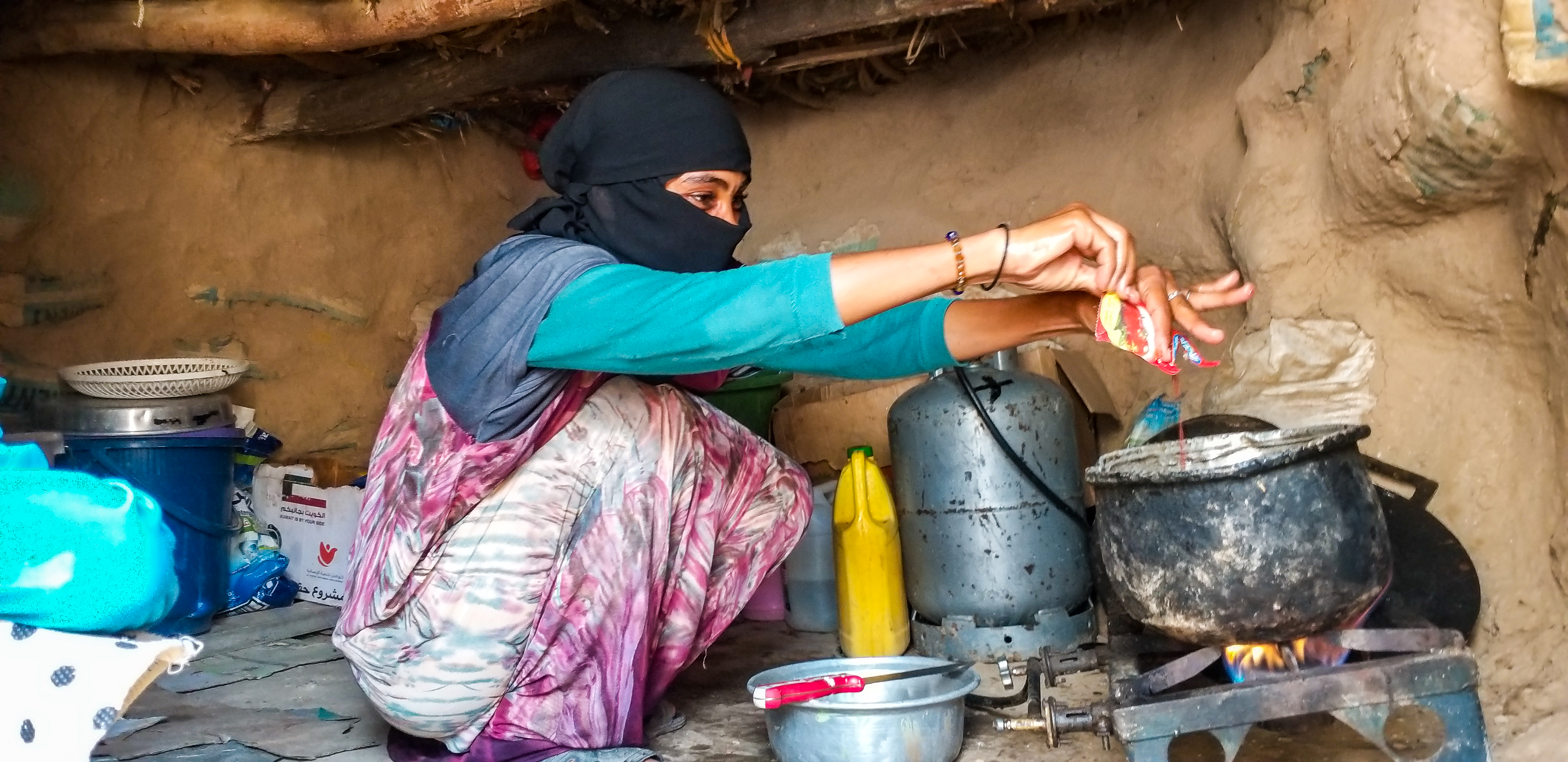 Alhan cooking for her daughters after a long day selling clothes in nearby cities. Photo: A. Zabl/IOM 2020