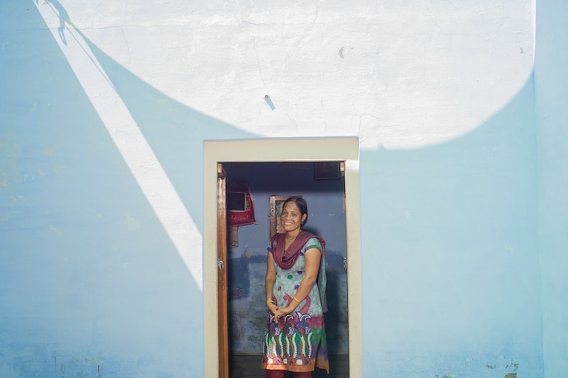 Anuradha standing in a doorway smiling.