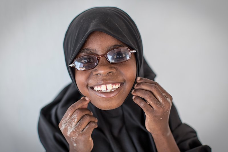 Rehema smiling, wearing her glasses.