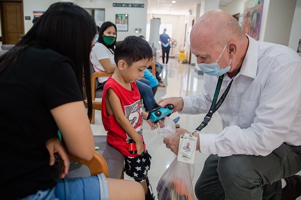 Executive Director Peter hands out wooden toy cars given by generous partners to our patients.