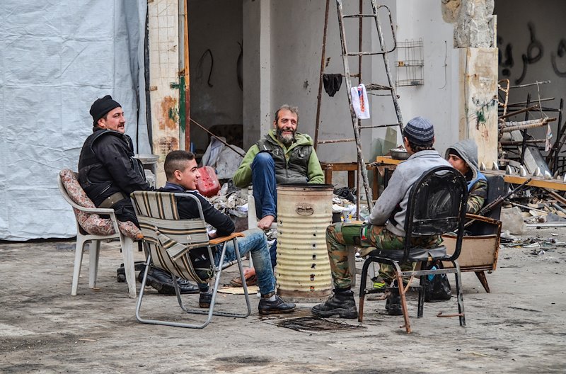 Civilians and young soldiers chat and laugh. In safety for the first time since 2012.