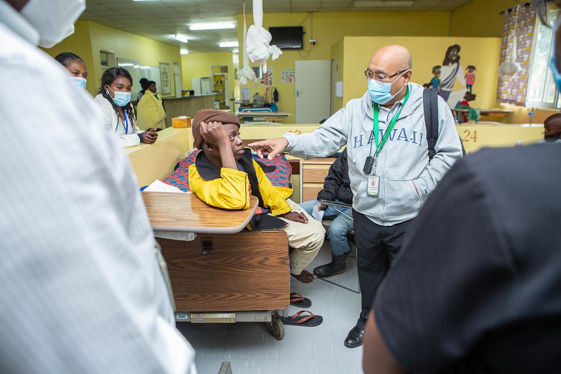 Dr. Felicilda speaking to a cleft lip patient Shadreck with others listening and learning.