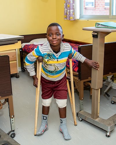 Misheck learning to walk with newly healed legs.