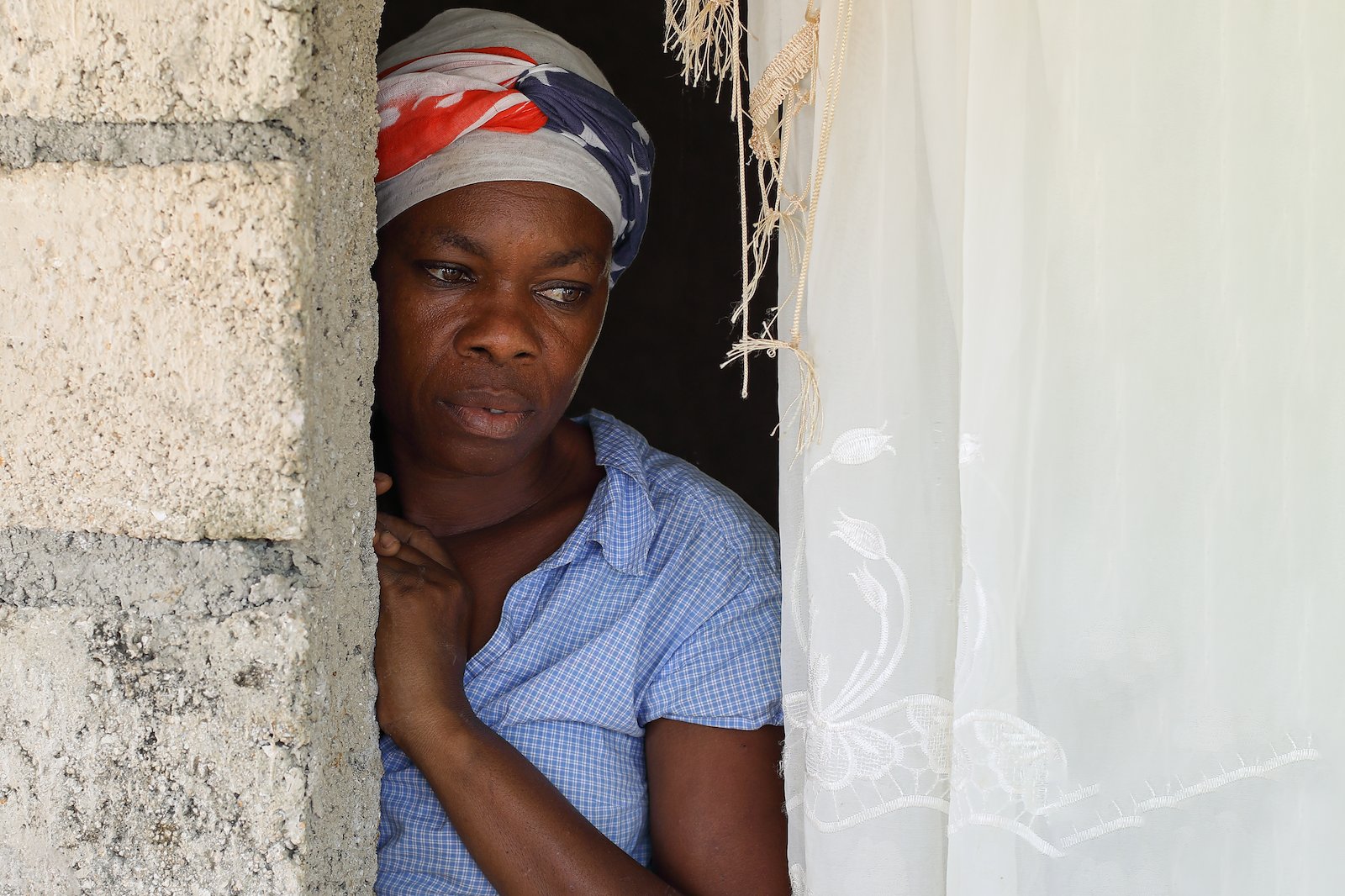 A woman peers out of her residence in Haiti's southern peninsula. Credit: UNOCHA/Christian Cricboom