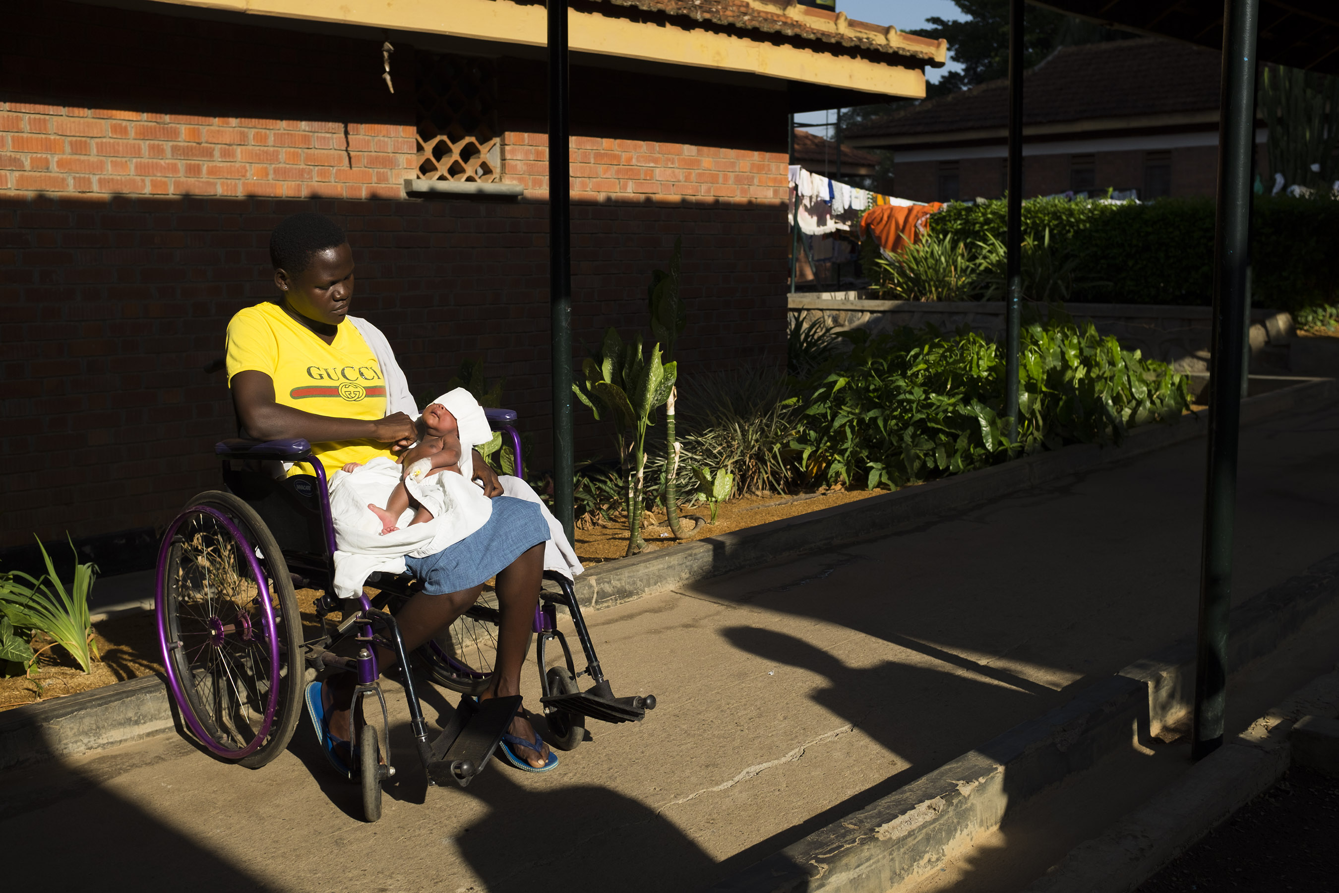 Shamim holds her son, Swaibu ,as they sit in the sun. Swaibu was low in ...