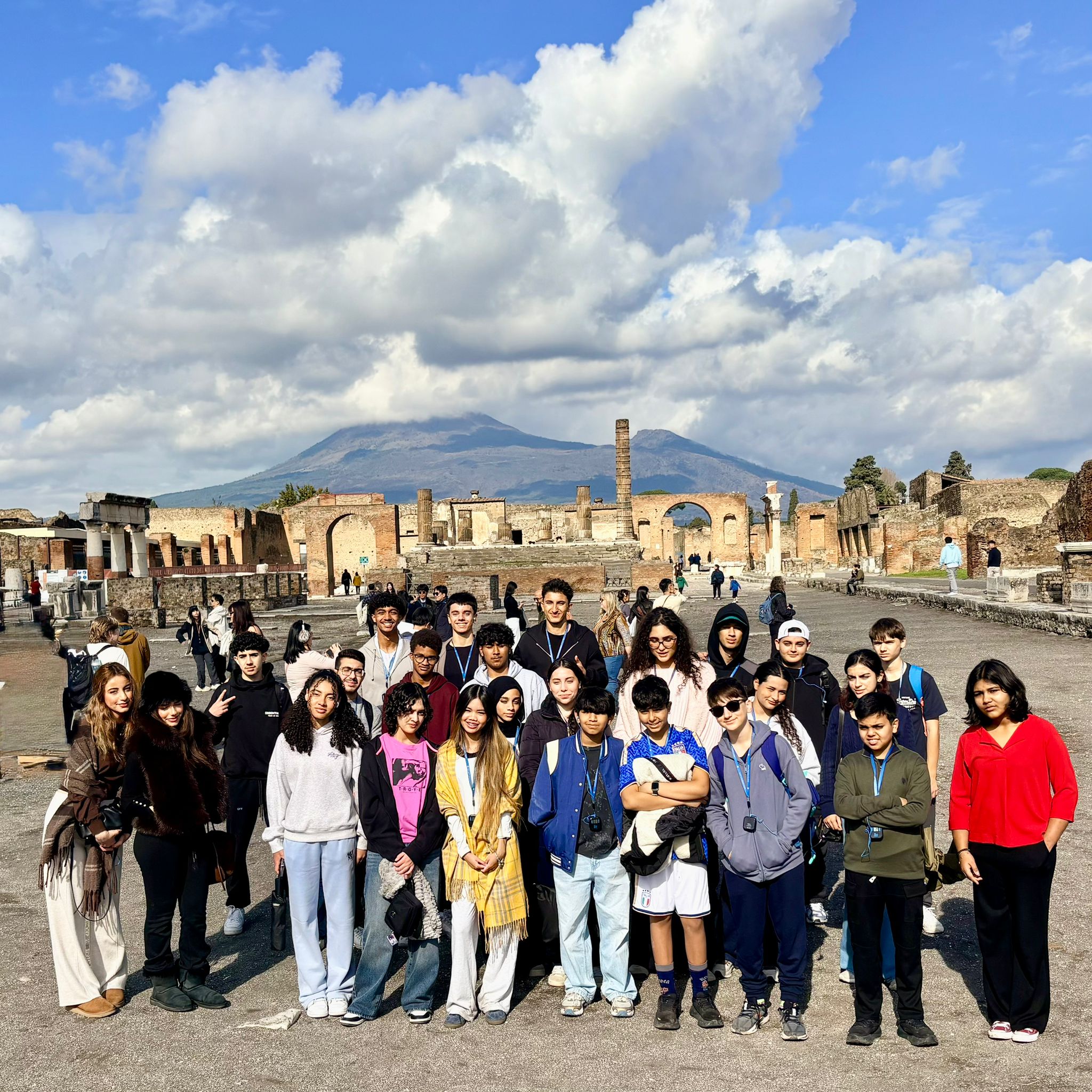 Group of students pose in Pompeii ruins with Mount Vesuvius in ...
