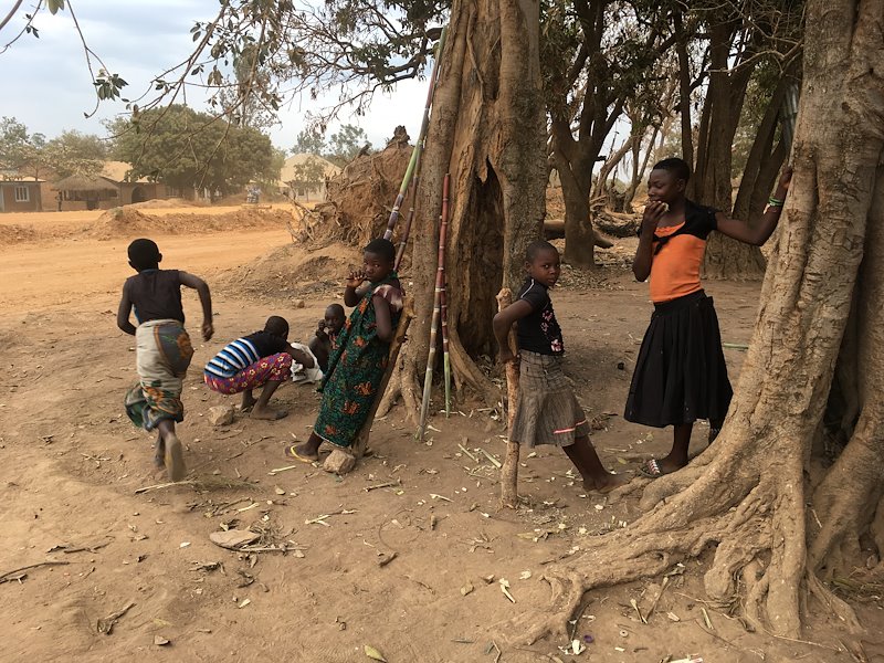 Children playing and selling sugarcane in the village