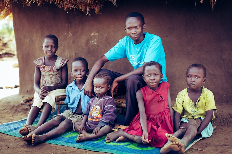 John and the children he is helping support. All have lost or been separated from their parents. Their ages range from 3 to 10.