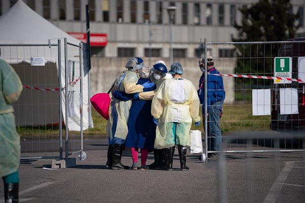A patient embraces her nurses and translators as she is discharged from the SP field hospital in Cremona.