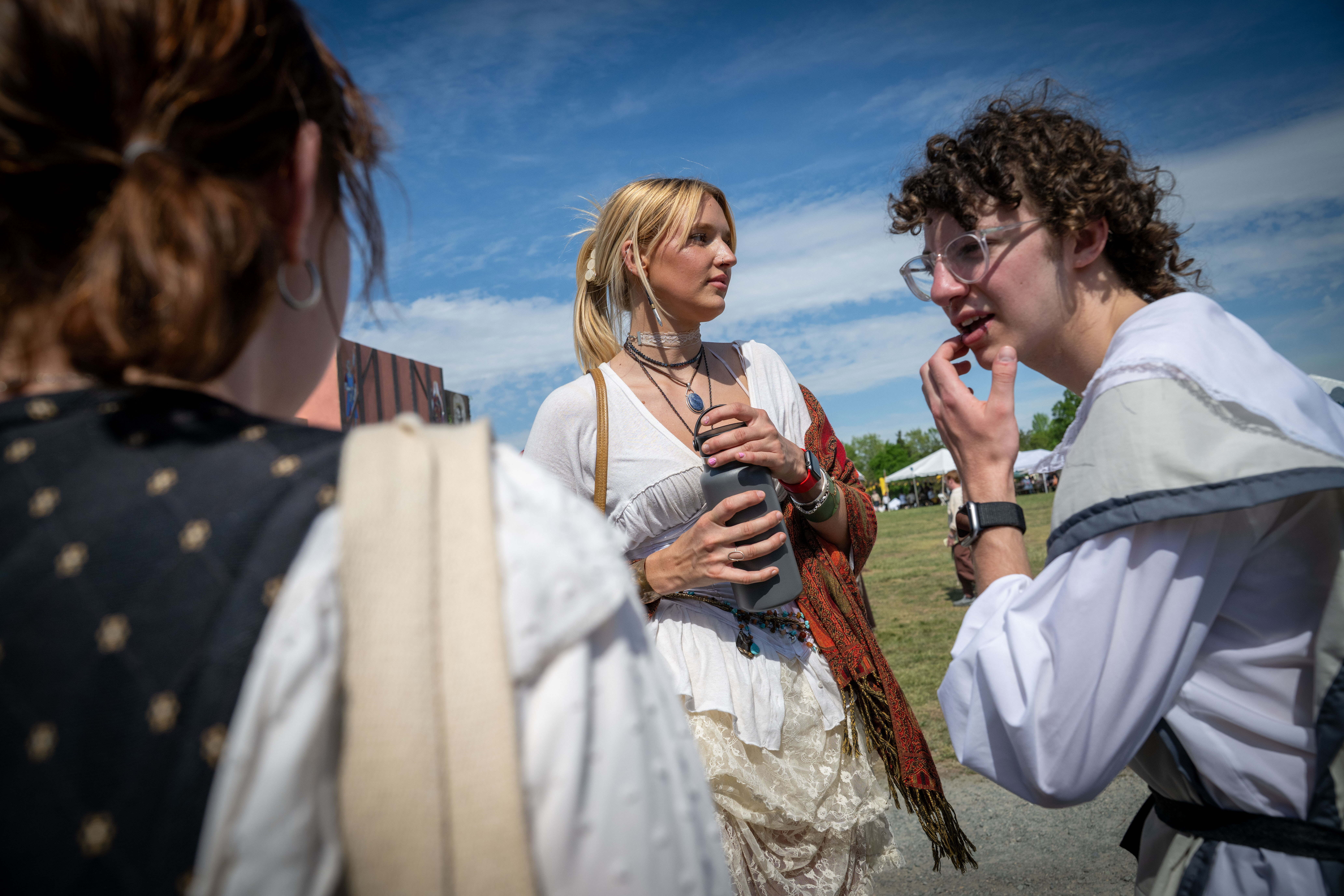 Two young people in Renaissance-style clothing converse at an outdoor ...