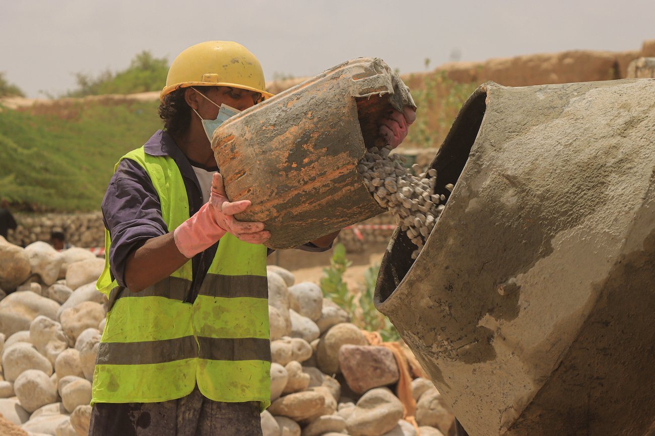 محمد صالح، 22 عاماً، يعمل في بناء قنوات الري وحواجز المياه من خلال نظام النقد مقابل العمل. مصدر الصورة: برنامج الأمم المتحدة الإنمائي في اليمن / 2022