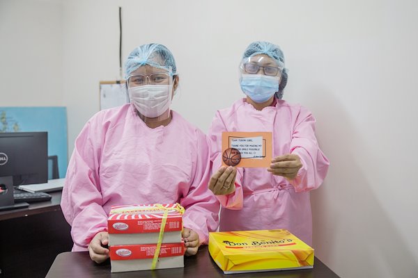 Social Workers Mona and Gina are happy to receive sweets from a grateful patient who received treatment at CURE Philippines.