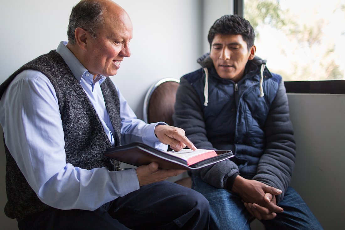 Pastor David Archondo, a native Boliviano, counsels a parent from the Word of God.