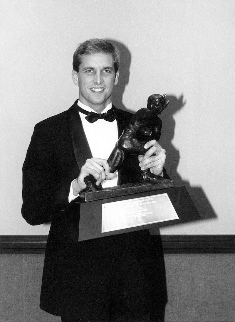 Ty Detmer poses with the Heisman Award which he won after the 1990 season.