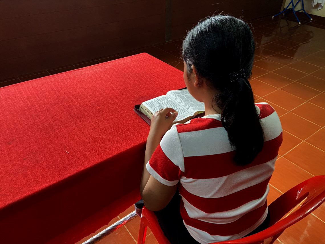 Soy reading her Bible, received from OD local partners in Laos