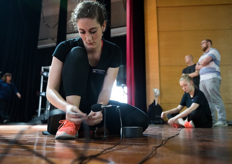 Brenna Daniels sets up microphones for a performance at the Vietnam Dance Academy. Photo by Jaren Wilkey/BYU