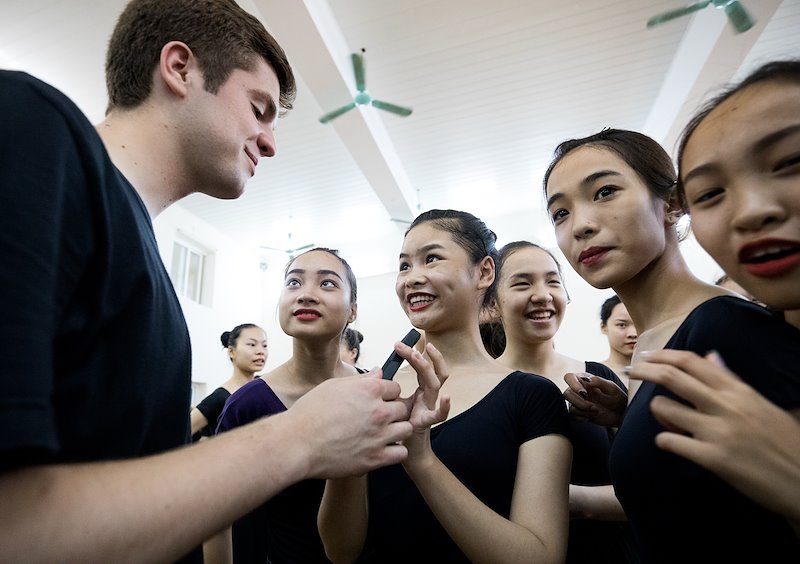 Taylon Mann exchanges contact information with dancers from the Vietnam Dance Academy. Photo by Jaren Wilkey/BYU